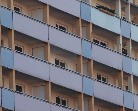 Wohngeldkürzungen gefährden hunderttausende Haushalte; Bewohner vor ihrem Wohnhaus in besorgter Stimmung.