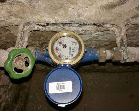 Absperrhahn und Wasseruhr symbolisieren neue städtische Trinkwasser- und Abwasserversorgung in Potsdam.