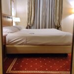 Hotelzimmer mit Bett, symbolisiert Schlafstörungen und deren Auswirkungen auf Lebensqualität.