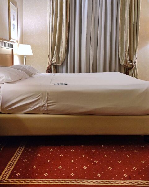 Hotelzimmer mit Bett, symbolisiert Schlafstörungen und deren Auswirkungen auf Lebensqualität.