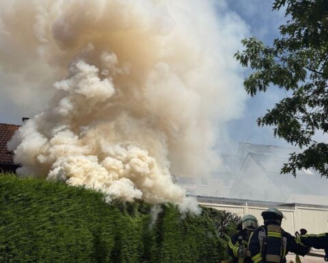 Rauchentwicklung über einem Garagenhof, Feuerwehr im Einsatz, verletzte Personen, gelöscht und kontrolliert.