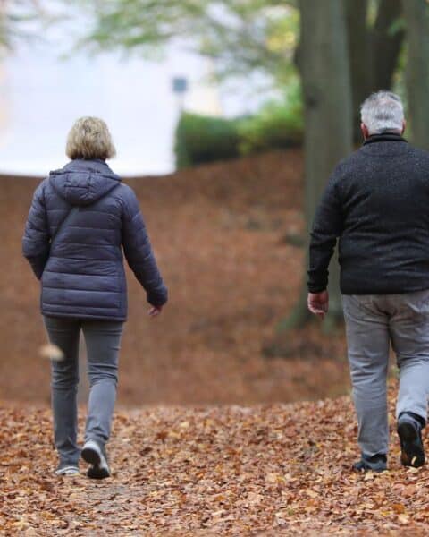 Älteres Paar betrachtet Renteninformation, symbolisiert steigende Rentenbeiträge und demografische Veränderungen.