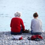 Alter und Jugend am Strand symbolisieren die Herausforderungen und Diskussionen zur Rentenreform.