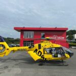 Rettungshubschrauber landet auf gesperrtem Parkplatz nach Unfall, Feuerwehr im Einsatz.