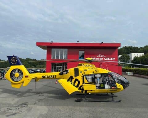 Rettungshubschrauber landet auf gesperrtem Parkplatz nach Unfall, Feuerwehr im Einsatz.