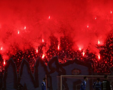 Fußball-Fans zünden Pyrotechnik im Stadion, während Sicherheitsdebatte um Stadiongewalt entbrannt ist.