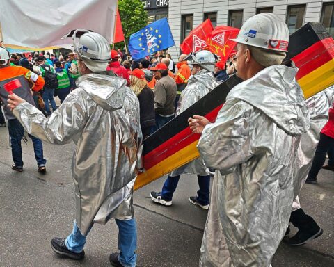 Demonstrierende Menschenwagen am Brandenburger Tor für die Zukunft der deutschen Stahlindustrie.