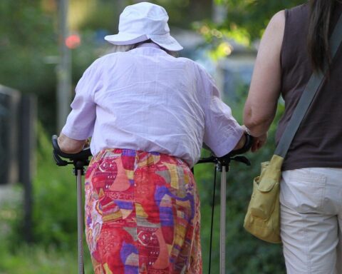 Seniorin erhält Unterstützung von Helferin, symbolisiert Pflege und Fürsorge in Thüringen.