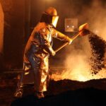 Stahlproduktion mit modernen Maschinen, Symbol für Industrie und Klimaschutz, im Hintergrund Zusammenarbeit und Fortschritt.