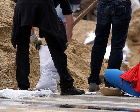 Hochwasser-Helfer füllen Sandsäcke, um Communities auf zukünftige Naturkatastrophen vorzubereiten.