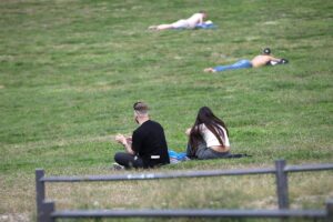 Junge Menschen genießen die warme Sommerzeit im Park unter strahlendem Sonnenschein.
