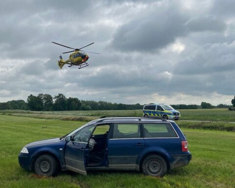 Zwei beschädigte Autos an einer Kreuzung, Polizei und Rettungskräfte am Unfallort.
