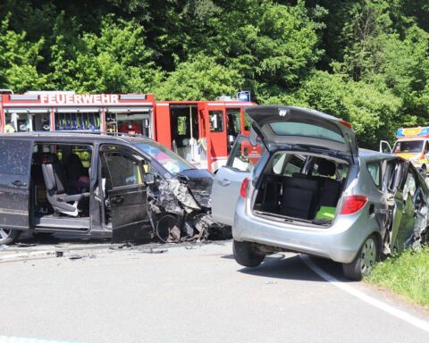 Zwei beschädigte Autos nach schwerem Verkehrsunfall, Polizei und Abschleppwagen vor Ort.