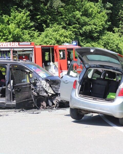 Zwei beschädigte Autos nach schwerem Verkehrsunfall, Polizei und Abschleppwagen vor Ort.