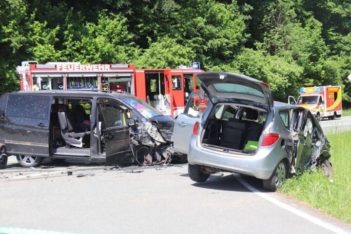 Zwei beschädigte Autos nach schwerem Verkehrsunfall, Polizei und Abschleppwagen vor Ort.