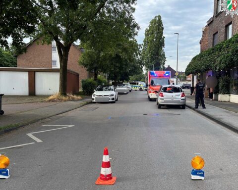 Pedelec-Fahrerin kollidiert mit wartendem Auto, schwere Verletzungen, Polizei und Rettungskräfte vor Ort.