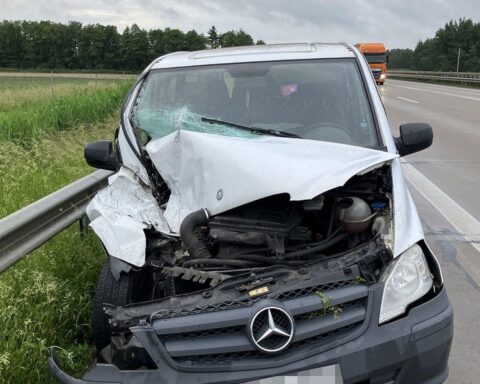 Verkehrsunfall auf Autobahn mit beschädigten Fahrzeugen und Polizei vor Ort, Sachschaden hoch.