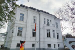 Städtische Landschaft mit hitzebeständigen Pflanzen und Plakaten für Klimaschutz und Wasserbewusstsein.