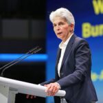 Marie-Agnes Strack-Zimmermann spricht leidenschaftlich auf FDP-Parteitag, Gesichter der Delegierten im Hintergrund.