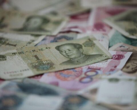 Chinesische Geldscheine neben Grafiken zu BIP und Handelsbilanzdefizit zwischen Deutschland und China.