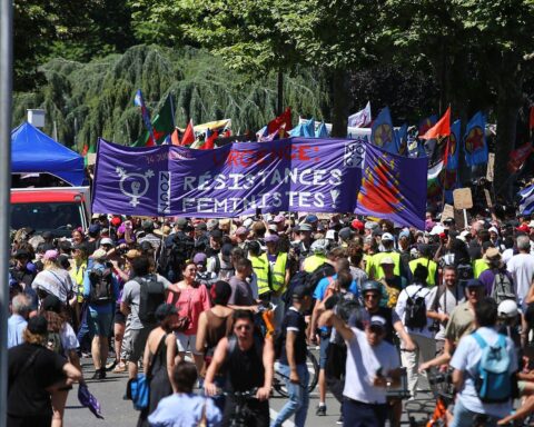 Menschen mit Plakaten und Fahnen protestieren gegen den G7-Gipfel in Genf.