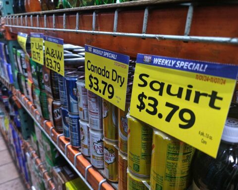 US-Supermarktregal mit Lebensmitteln, Preisschildern und Hinweisen auf Inflation und steigende Preise.