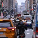 Schilder mit internationalen Zielen und Verkehrsszenen in New York, Symbol für Auswanderung.