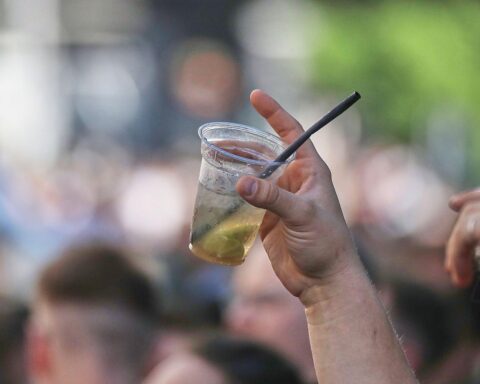 Mann hebt alkoholisches Getränk, symbolisiert Problematik von Alkohol am Steuer und Radfahren.