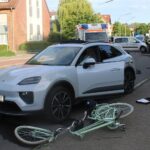 Unfallstelle mit beschädigten Fahrzeugen und einem schwer verletzten Radfahrer, Polizei vor Ort.