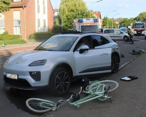 Unfallstelle mit beschädigten Fahrzeugen und einem schwer verletzten Radfahrer, Polizei vor Ort.
