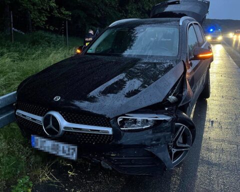 Beschädigter Mercedes nach Unfall, verursacht durch unbekannten Audi-Fahrer auf regennasser Autobahn.