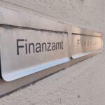 Finanzamt mit Fokus auf Ehegattensplitting und Familienförderung, betroffenes Paar diskutiert Steueroptionen.