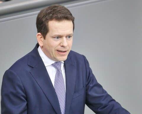 Martin Plum bei einer Diskussion, umgeben von politischen Symbolen der CDU und Bundestag.