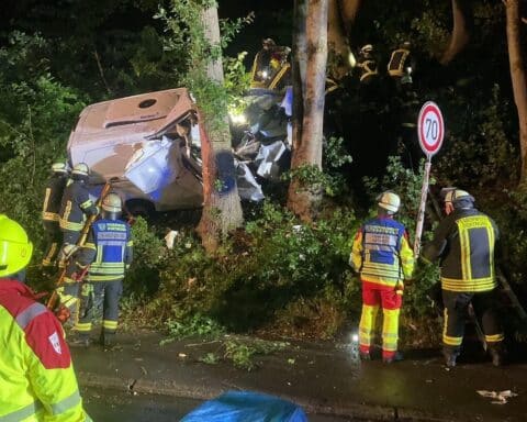 Unfallfahrzeug an Böschung, Feuerwehr rettet eingeklemmten Fahrer unter schwierigen Bedingungen.