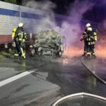 Feuerwehr löscht brennendes Fahrzeug nach schwerem Verkehrsunfall auf Autobahn 1.