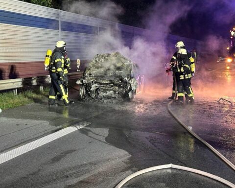 Feuerwehr löscht brennendes Fahrzeug nach schwerem Verkehrsunfall auf Autobahn 1.