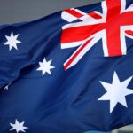 Australische Flagge vor Hintergrund von Vogelgrippewarnungen, symbolisiert den neusten H5N1-Fall.