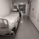Pflegende Angehörige im Krankenhaus, symbolisieren Unterstützungsbedarf und Änderungen in der Pflegeversicherung.