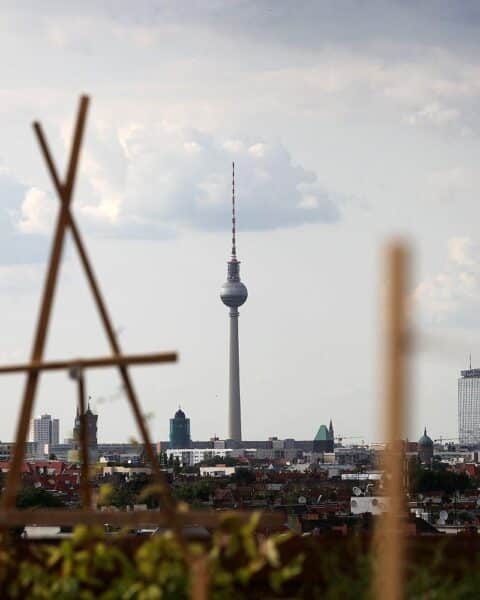 Dachterrasse in Berlin mit Blick auf den Fernsehturm und bewölkten Himmel.