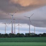Windräder vor bewölktem Himmel, symbolisieren das wechselhafte Wetter in Sachsen.