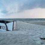 Umgekippter Strandkorb vor stürmischem Wetter; Symbol für die unbeständige Wetterlage in Norddeutschland.