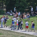 Junge Leute genießen den Sommer unter strahlendem Himmel; Hitzewarnung für Thüringen angekündigt.