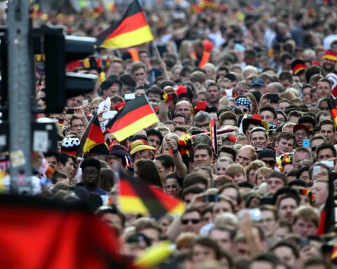 Fußballfans jubeln oder trauern, ihre Emotionen während wichtigem Spielereignis erlebend und dokumentierend.