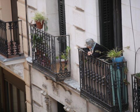 Seniorin auf Balkon, besorgt über Wohngeldkürzungen, die Rentner stark betreffen könnten.