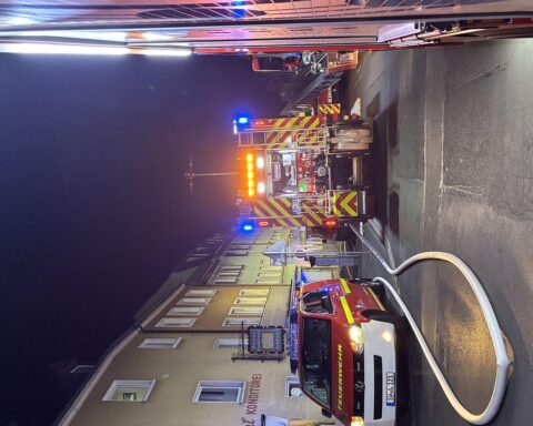 Feuerwehr im Einsatz, Menschenrettung, Feuerwehrmann löscht, brennendes Mehrfamilienhaus in Schweinfurt.