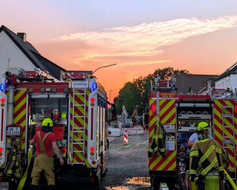 Feuerwehr löscht Zimmerbrand: Einsatzkräfte, Rauch, Löschaktion, zerstörte Wohnung, Hilfsbereitschaft.