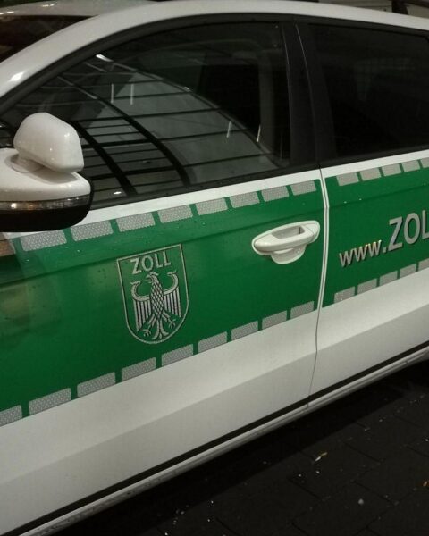 Zollbeamte inspektieren Container, Kokainversteck sichtbar, erfolgreicher Drogenkampf in Wilhelmshaven.