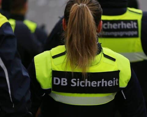 Zugbegleiter kontrolliert Fahrkarten; aggressiver Passagier wird von Polizei im Hauptbahnhof Stuttgart abgeführt.