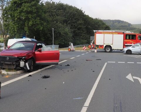 Unfall auf der B64 bei Bad Driburg: zwei kollidierte Autos, Verkehrsinsel beschädigt, Polizei am Einsatzort.