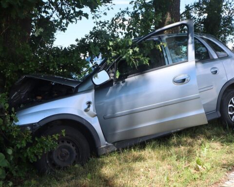 Unfallstelle mit Opel Corsa, Baum, und Rettungswagen nach schwerer Verletzung einer Autofahrerin.